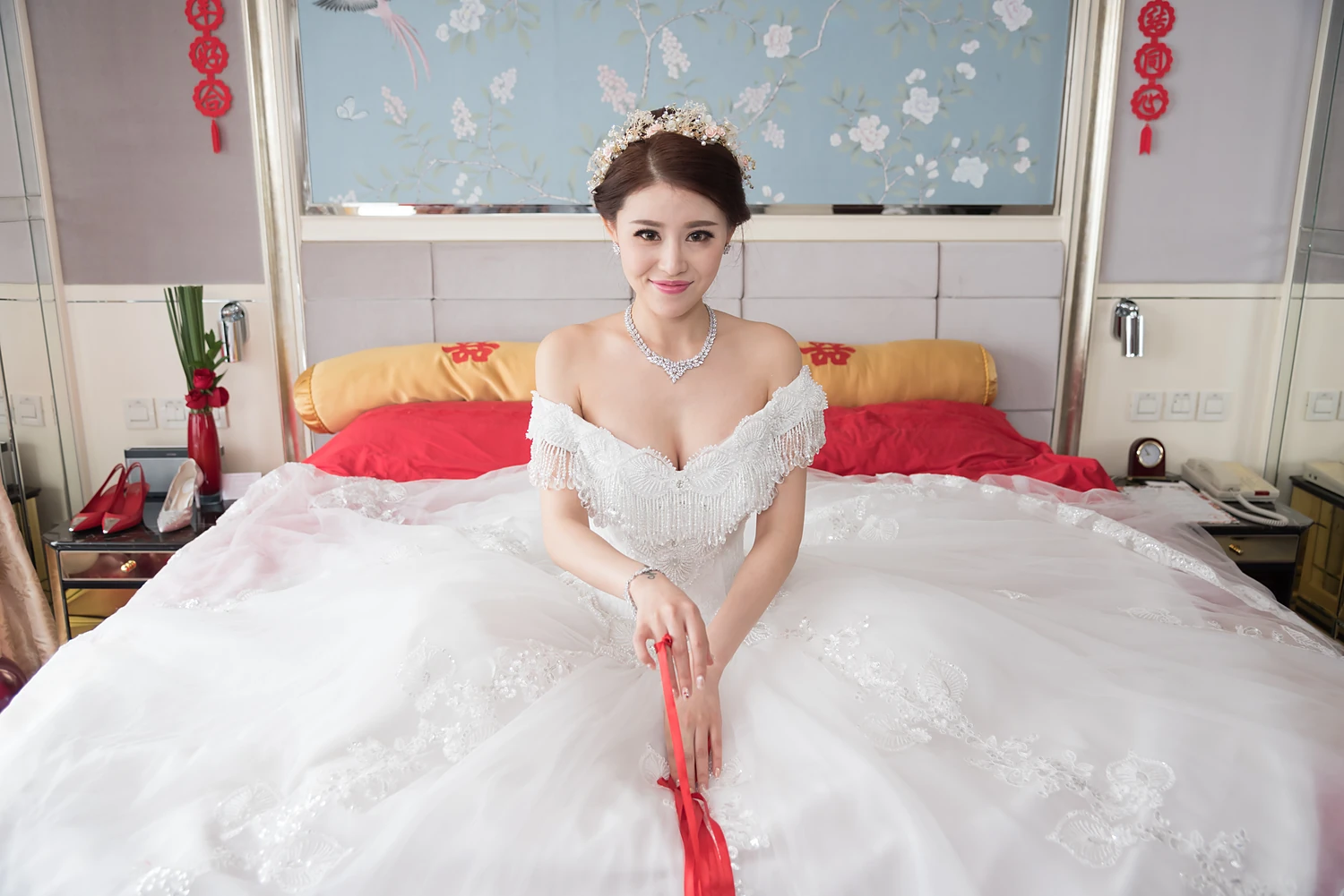 [素人新娘] 花朵发冠配钻石项链，白亮片流苏一字肩大摆纱，坐在囍字喜床上捏红绳笑的新娘婚礼现场实拍写真 【H960】
